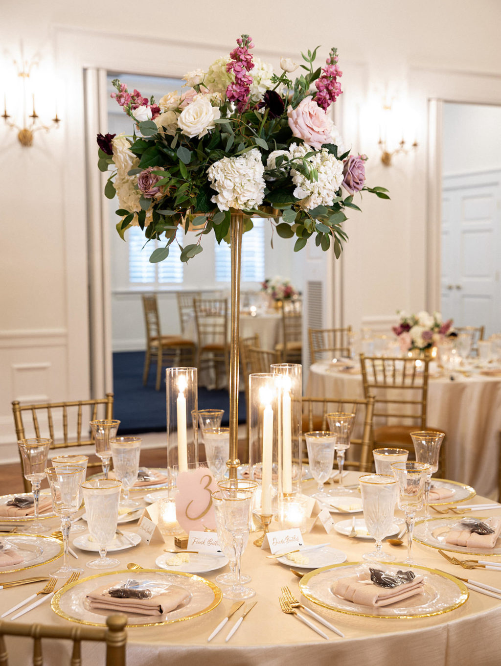 Classic Wedding Reception Decor, Champagne Table Linen, Gold Rimmed and Clear Glass Chargers, Bush Pink Linen Napkins, Tall Floral Centerpiece, White Hydrangeas, Mauve Roses, Greenery Eucalyptus | Tampa Bay Wedding Rentals Kate Ryan Event Rentals