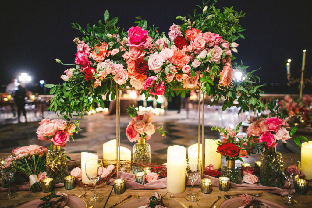 Luxury Elegant Tampa Wedding Reception with Long Feasting Tables featuring Tall Colorful Peach, Blush Pink, Fuchsia and Orange Rose Centerpieces with Greenery and Candles