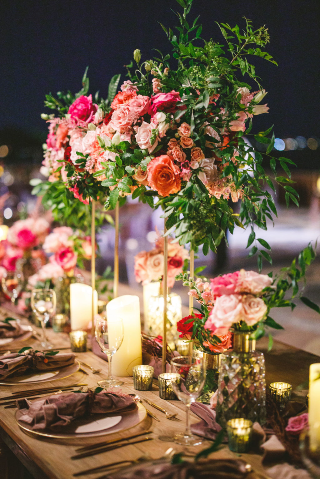 Luxury Elegant Tampa Wedding Reception with Long Feasting Tables featuring Tall Colorful Peach, Blush Pink, Fuchsia and Orange Rose Centerpieces with Greenery and Candles