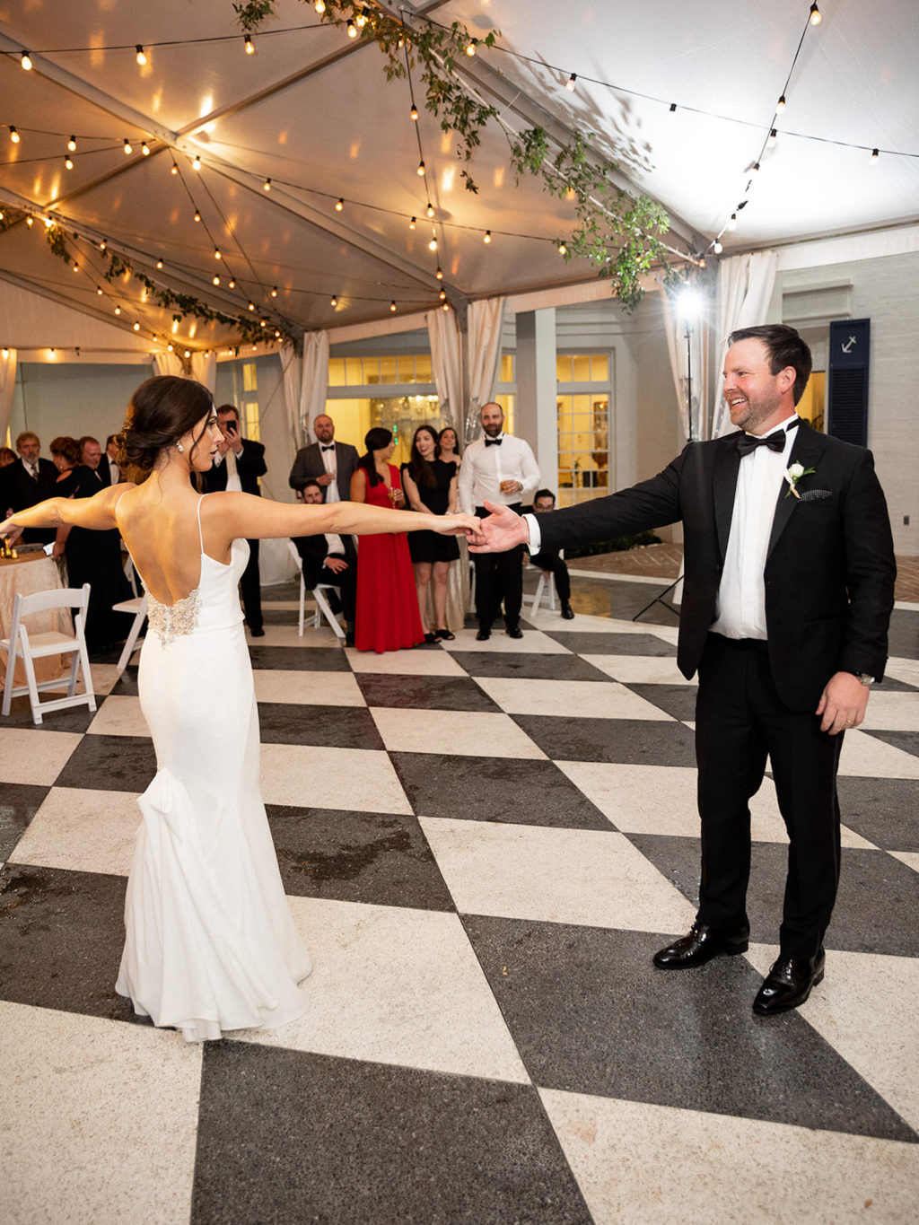 Classic Bride and Groom First Dance Wedding Reception Photo, String Lights, Black and White Checkered Dance Floor | Tampa Bay Wedding Rentals Kate Ryan Event Rentals