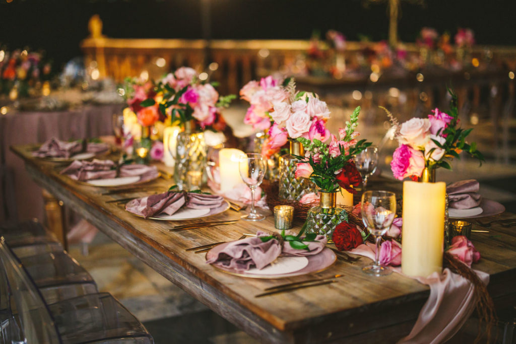 Luxury Elegant Tampa Wedding Reception with Long Wood Feasting Tables featuring Colorful Peach, Blush Pink, Fuchsia and Orange Rose Centerpieces with Greenery and Candles