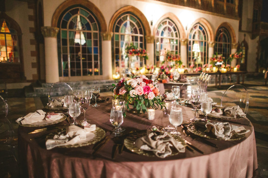 Outdoor Historic Mansion Ca'd'Zan Ringling Tampa Sarasota Wedding Reception with Round Tables with Dusty Rose Mauve Velvet Linens, Gold Glass Charger Plates and Clear Ghost Chairs