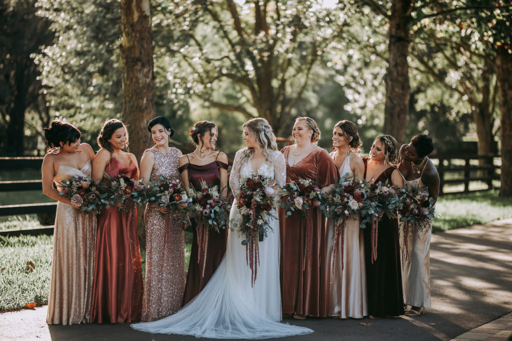 Florida Bride and Bridesmaids in Mismatched Champagne, Burnt Orange and Burgundy Dresses Holding Lush Rustic Floral Bouquets | Bella Bridesmaid