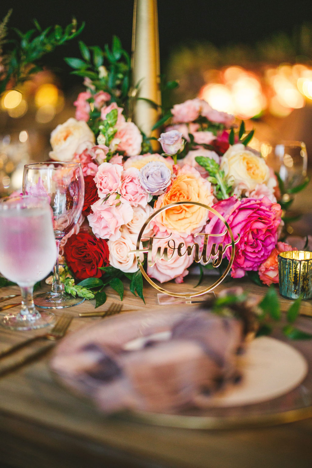 Colorful Peach, Blush Pink, Fuchsia and Orange Rose Centerpieces with Greenery and Candles | Gold Die Cut Round Wedding Table Number