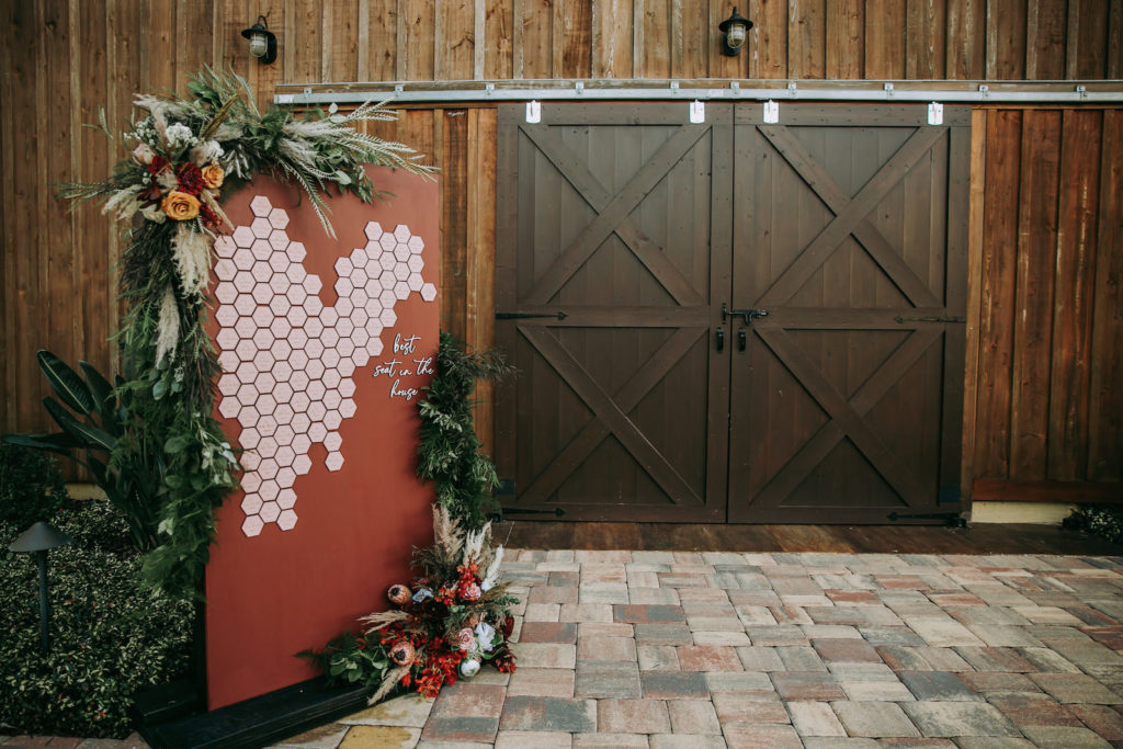 Rustic Barn Wedding Reception Decor, Unique Burnt Orange Wall with Geometric Tile Seating Chart, Lush Floral Arrangements, Pampas Grass, Mustard Yellow and Burgundy Roses, King Proteas | Tampa Bay Wedding Venue Mision Lago Estate | Mision Lago Ranch