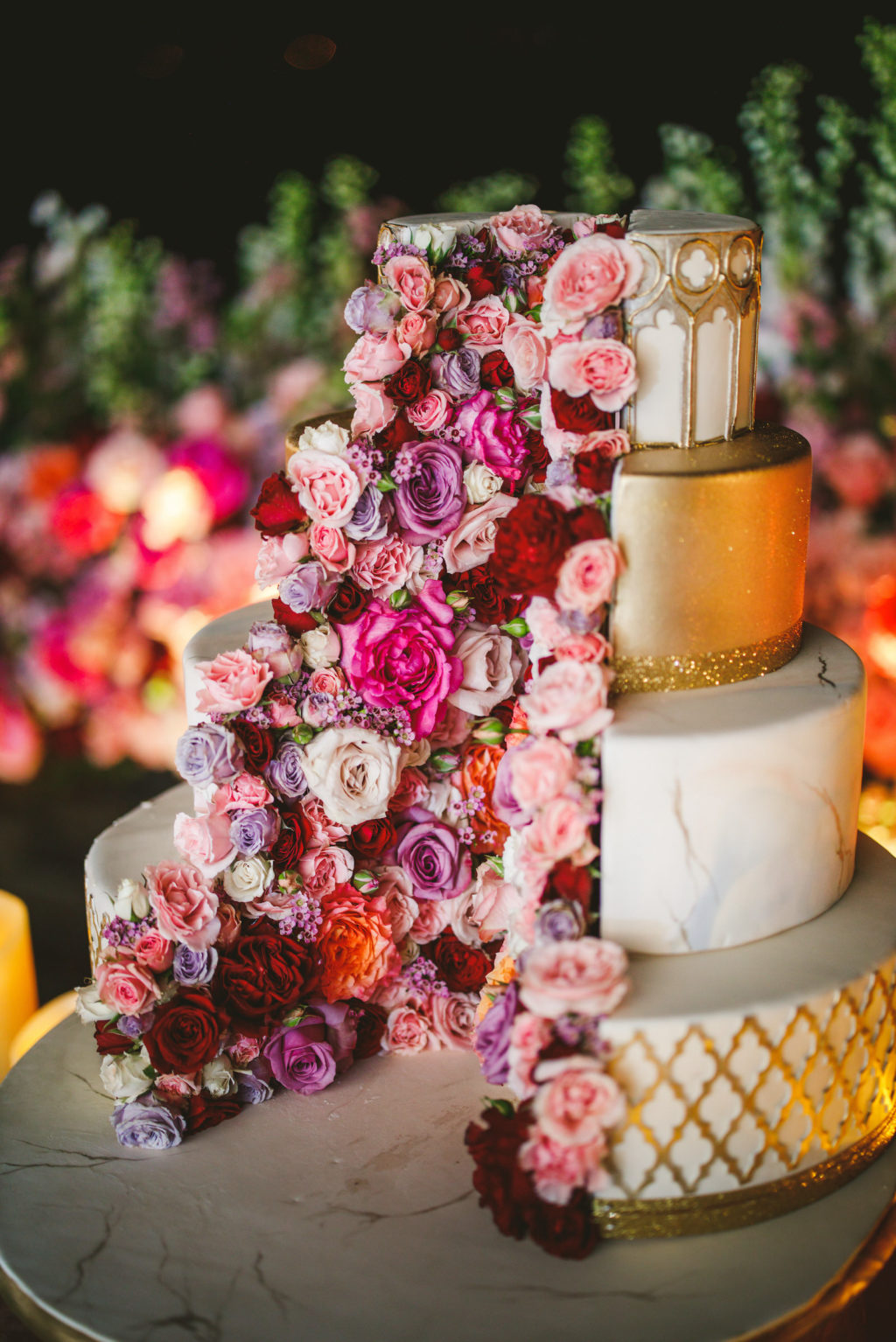 Four Tier White and Metallic Gold Fondant Luxury Wedding Cake by The Artistic Whisk featuring Colorful Fresh Flower Pink Purple and Orange Roses
