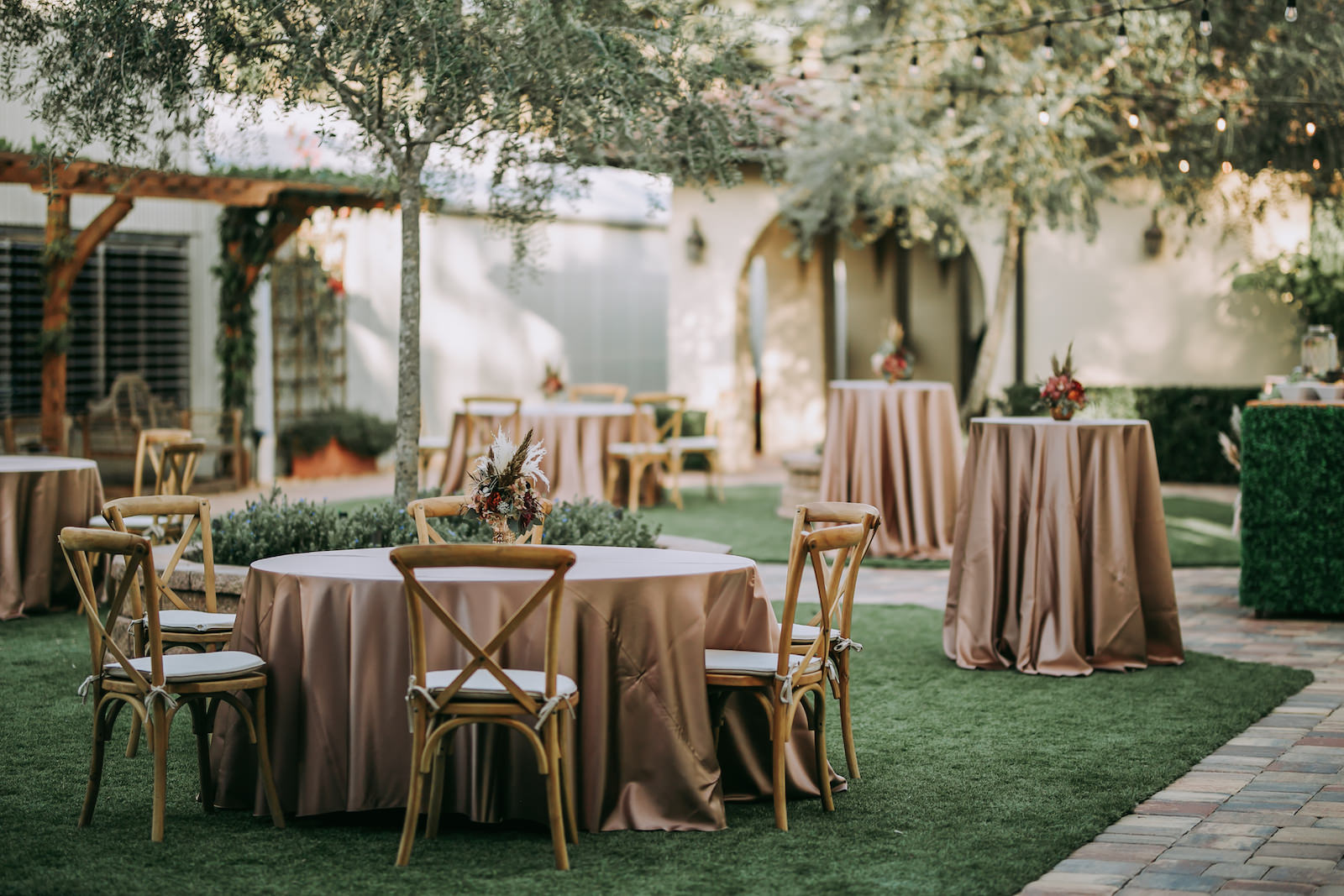 Outdoor Wedding Cocktail Hour Decor, Wooden Cross Back Chairs with Champagne/Gold/Dusty Rose Table Linen and Small Floral Centerpiece, Tall Cocktail Tables | Tampa Barn Wedding Venue Mision Lago Estate | Mision Lago Ranch