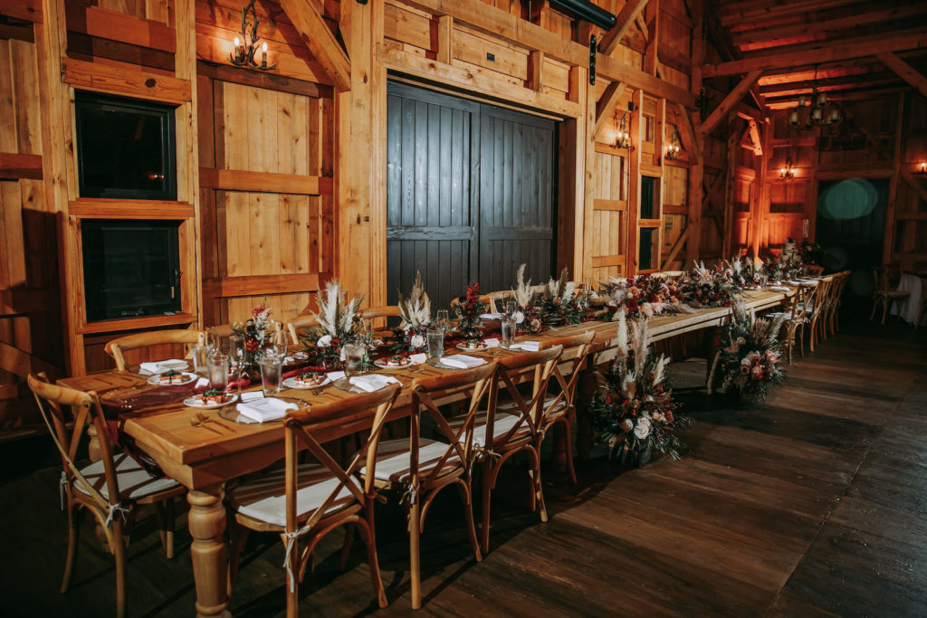 Rustic Barn Wedding Reception Decor, Long Wooden Feasting Table for Wedding Party, Wooden Crossback Chairs, Pampas Grass, Greenery | Tampa Wedding Venue Mision Lago Estate | Mision Lago Ranch