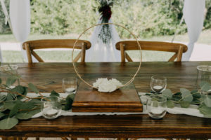 Garden Wedding Reception Decor, Wooden Sweetheart Table, Wooden Crossback Chairs, Circular Gold Centerpiece with White Roses, Eucalyptus and Ivory Table Runner | Tampa Bay Wedding Photographer Amber McWhorter Photography | Wedding Florist Brides & Blooms