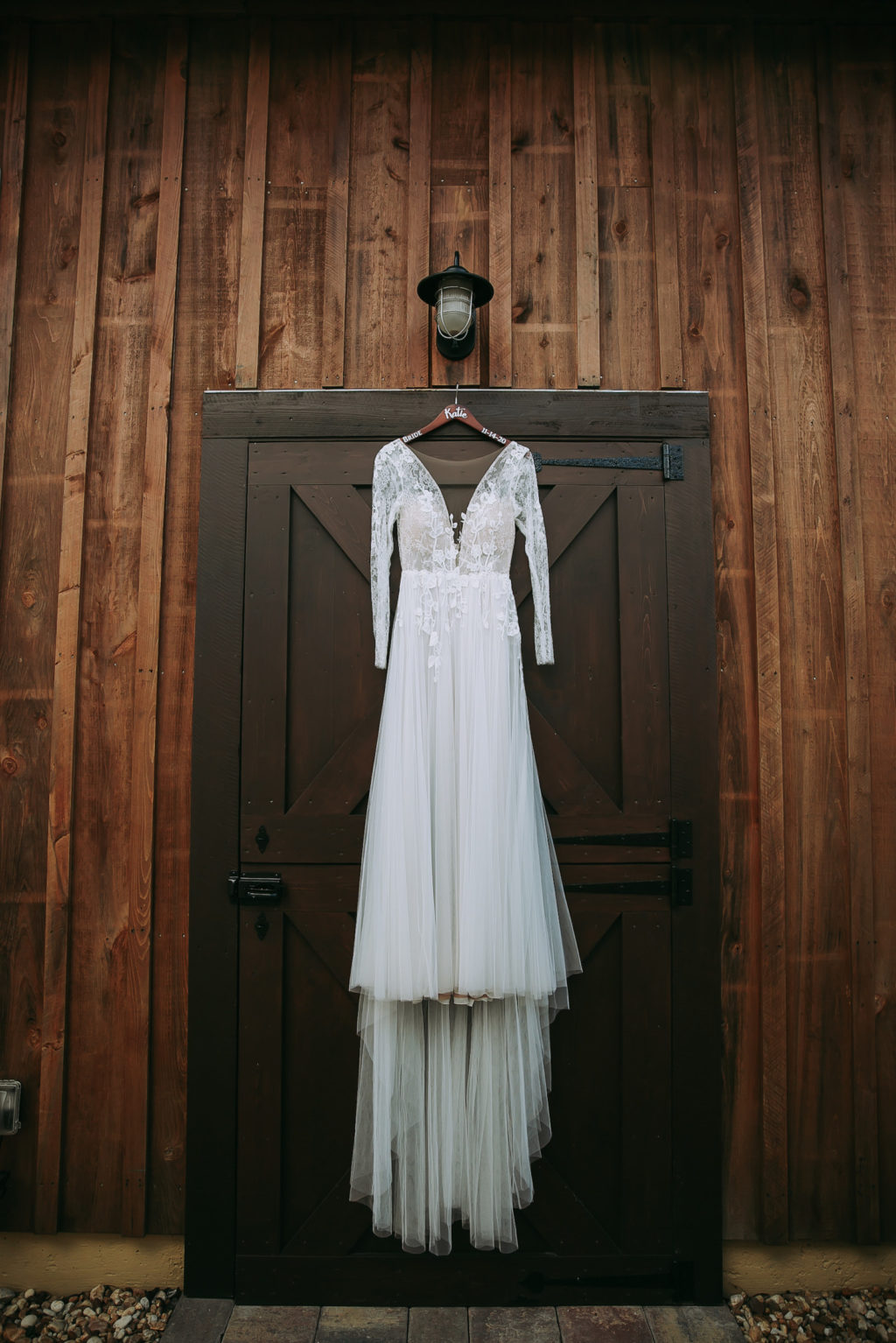 Long Sleeve Lace and Illusion Plunging V neckline Hanging on Barn Door | Tampa Wedding Venue Mision Lago Estate