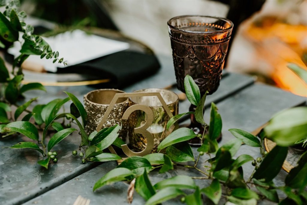 Moody Fall Winter Wedding Vintage Beaded Goblet Water Wine Glassware by Kate Ryan Event Rentals | Gold Geometric Table Number with Greenery Garland Runner and Mercury Glass Votive Candles