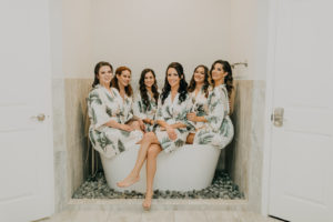 Florida Bride and Bridesmaids in Matching Palm Tree Leaves Printed Bath Robes Sitting on Tub Getting Wedding Ready | Tampa Bay Wedding Photographer Amber McWhorter Photography