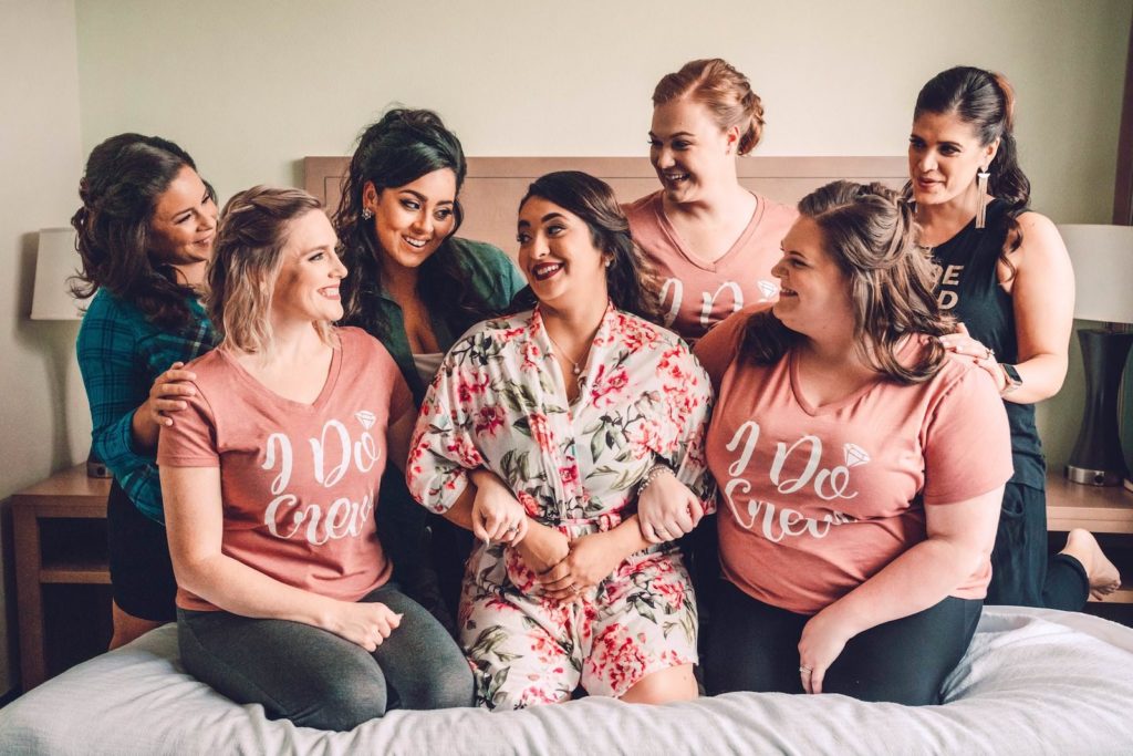 Florida Bride in Floral Robe and Bridesmaids in Graphic Tees "I Do Crew" Getting Ready on Bed | Tampa Bay Wedding Photographer Bonnie Newman Creative