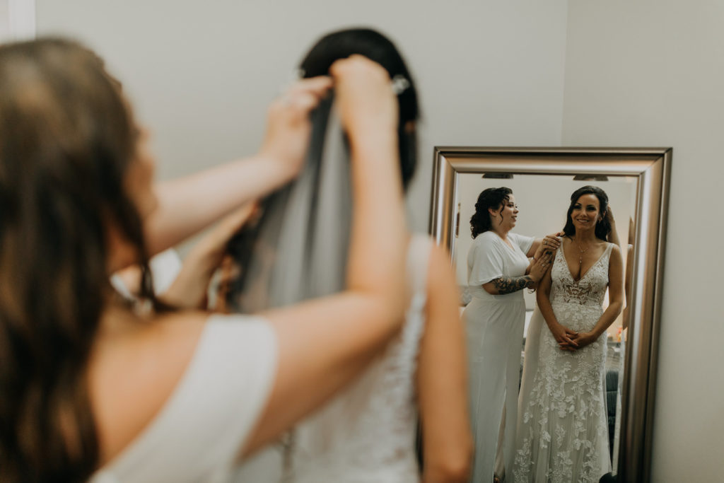 Florida Bride Getting Wedding Ready Putting on Wedding Veil Wearing Lace and Illusion Plunging V Neckline Wedding Dress | Tampa Bay Wedding Photographer Amber McWhorter Photography