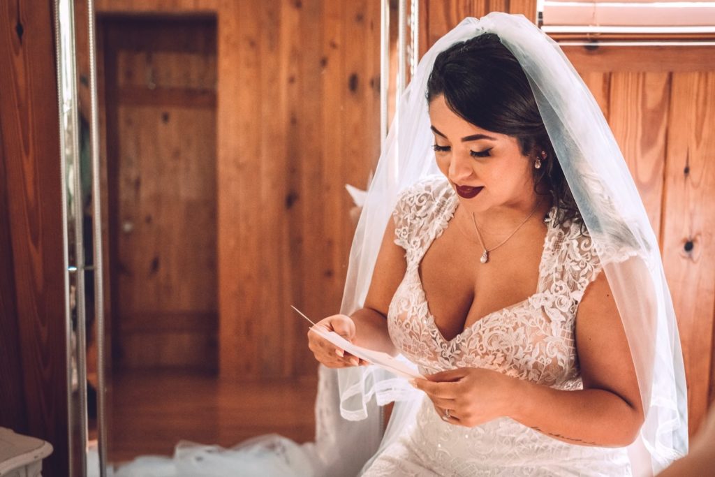 Florida Bride Reading Letter from Groom Wearing Cap Sleeve Romantic Lace V Neckline Wedding Dress and Veil | Tampa Bay Wedding Photographer Truly Forever Bridal