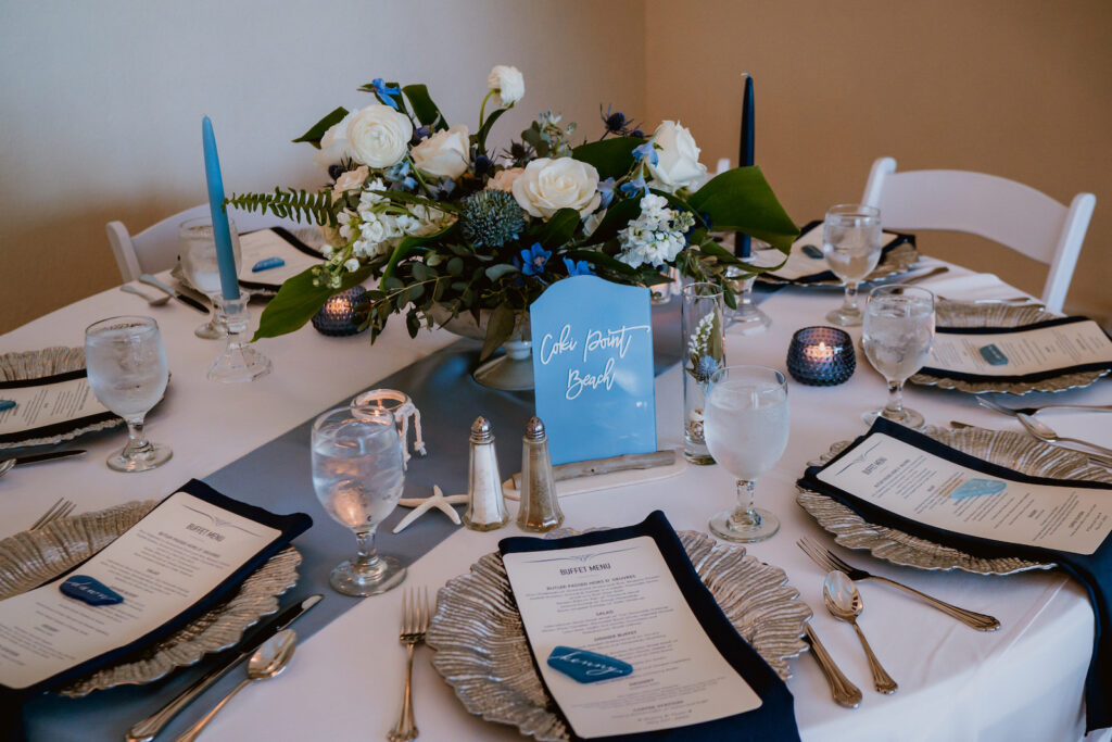 Dusty Blue Coastal Wedding Tablescape with White and Greenery Floral Centerpiece, Silver Scalloped Chargers