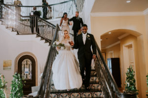 Timeless Elegant Bride and Groom Walking Down Staircase at Tampa Bay Wedding Venue Westshore Yacht Club
