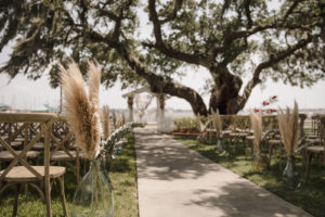 Waterfront Wedding Ceremony with Pampas Leaves and Greenery Adorning the Aisle | Sarasota Wedding Planner Kelly Kennedy Wedding and Events