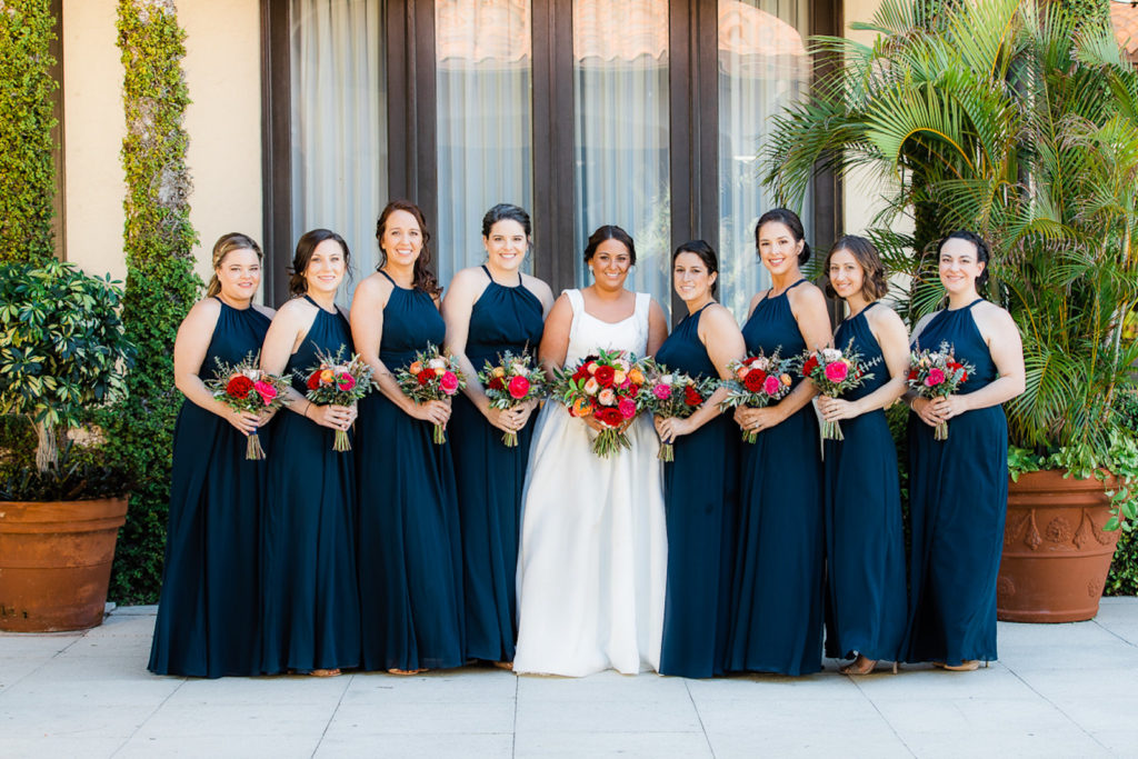 Bride and Bridesmaids in Matching Halter Navy Blue Dresses Holding Jewel Tone Floral Bouquets