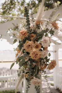 Neutral Cream and Burnt Orange Rose Detail on Wedding Alter with Mixed Greenery and Pampas Leaves | Boho Florida Waterfront Wedding Ceremony