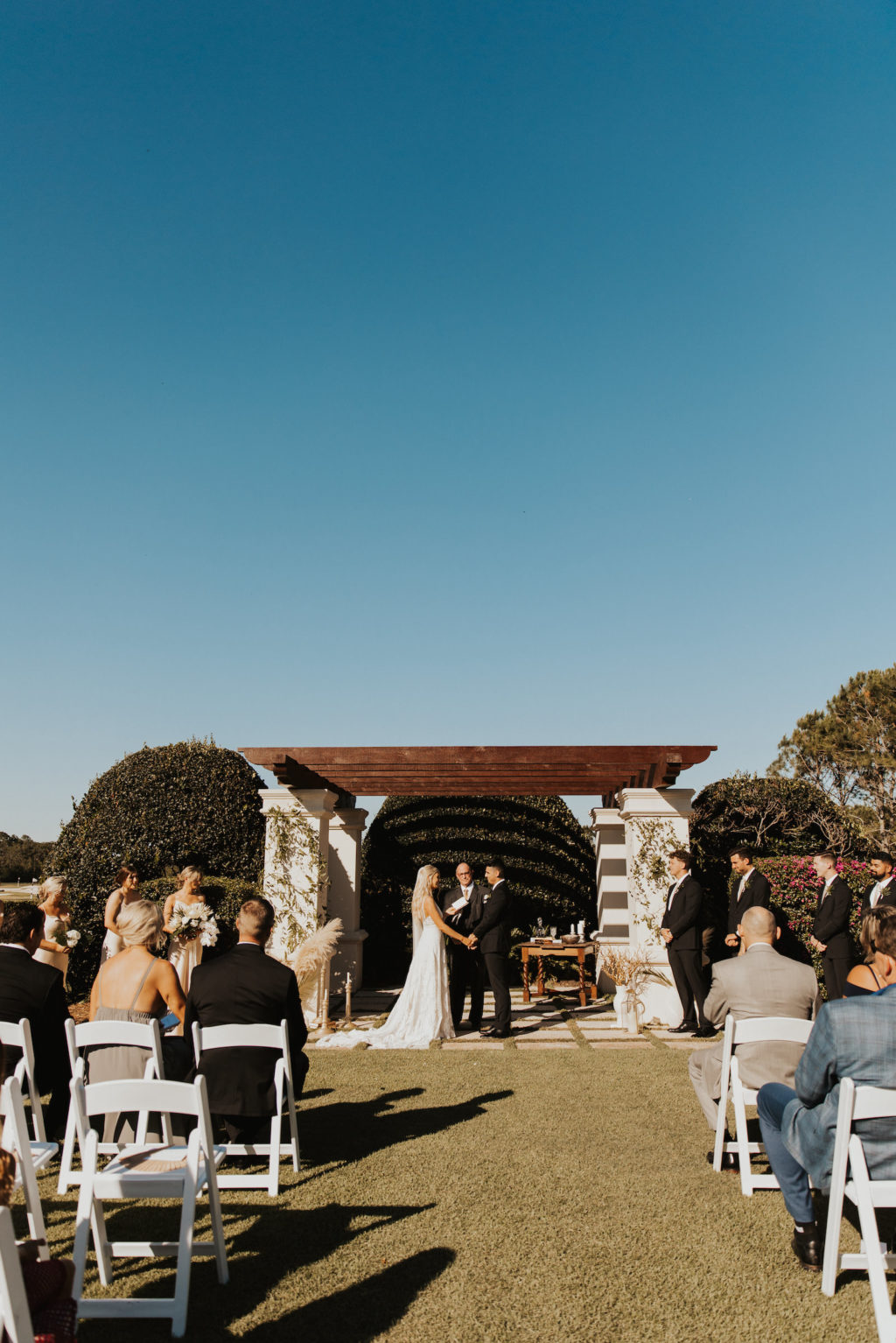 Timeless Bride and Groom Exchanging Wedding Vows Under Outdoor Pergola | Tampa Wedding Venue The Concession Golf Course