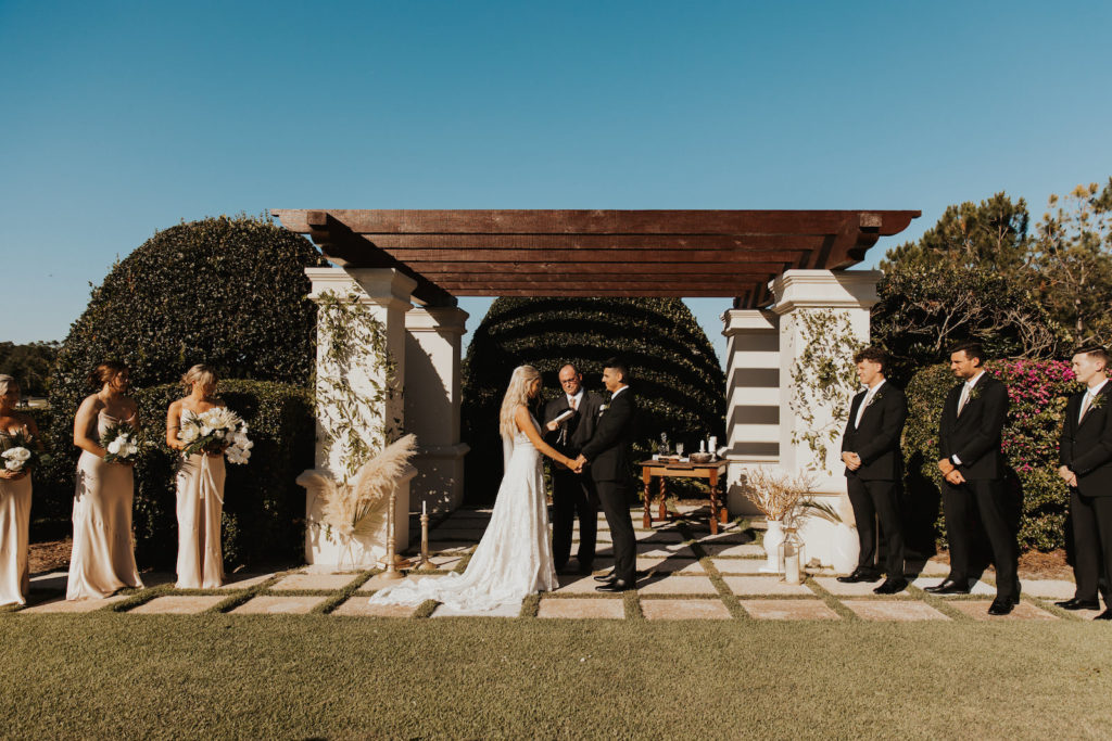 Timeless Bride and Groom Exchanging Wedding Vows Under Outdoor Pergola | Tampa Wedding Venue The Concession Golf Course