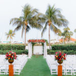 Elegant Waterfront Outdoor Garden Wedding Ceremony Decor, White Folding Chairs, Tall Wooden Aisle Pedestals with Jewel Tone Floral Arrangements, Arch with White Linens and Flowers | Tampa Bay Wedding Venue The Resort at Longboat Key Club