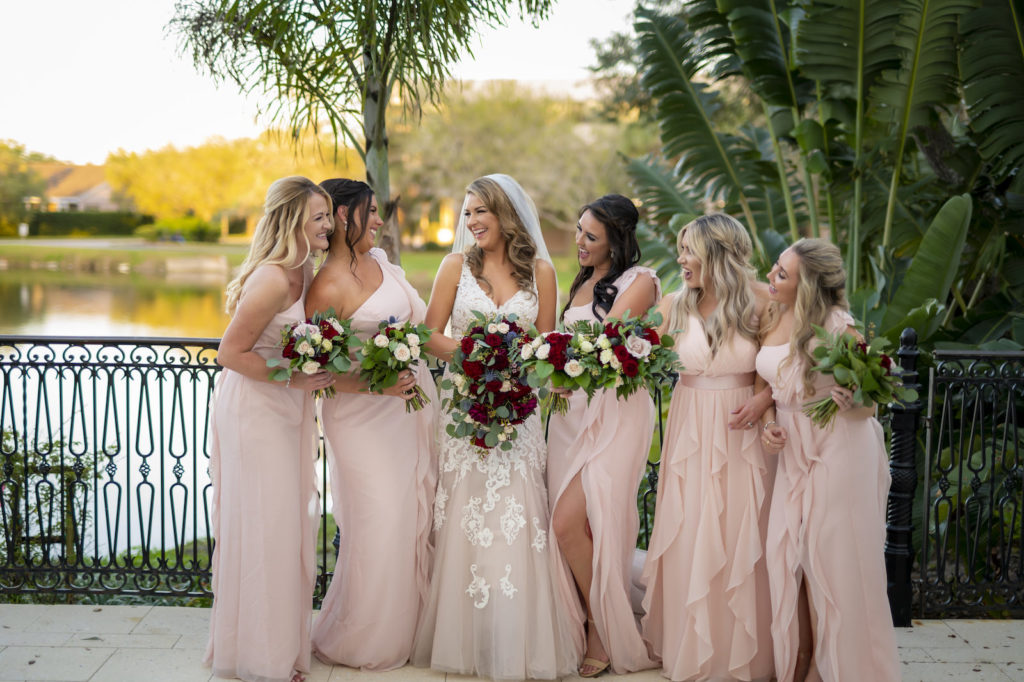 Florida Bride Holding Burgundy Roses and Greenery Floral Bouquet with Bridesmaids in Blush Pink Mix and Match Bridesmaids Dresses
