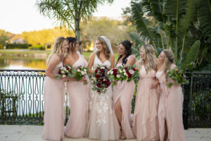 Florida Bride Holding Burgundy Roses and Greenery Floral Bouquet with Bridesmaids in Blush Pink Mix and Match Bridesmaids Dresses