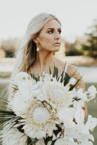 Timeless Bride Holding Lush Neutral Floral Bouquet, King Proteas, White Orchids, Palm Fronds