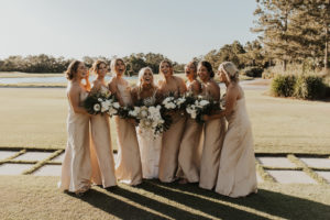 Neutral Timeless Bride with Bridesmaids in Silky Matching Champagne Gold Dresses Holding Floral Bouquets with White Roses and Palm Fronds | Tampa Bay Wedding Venue The Concession Golf Course