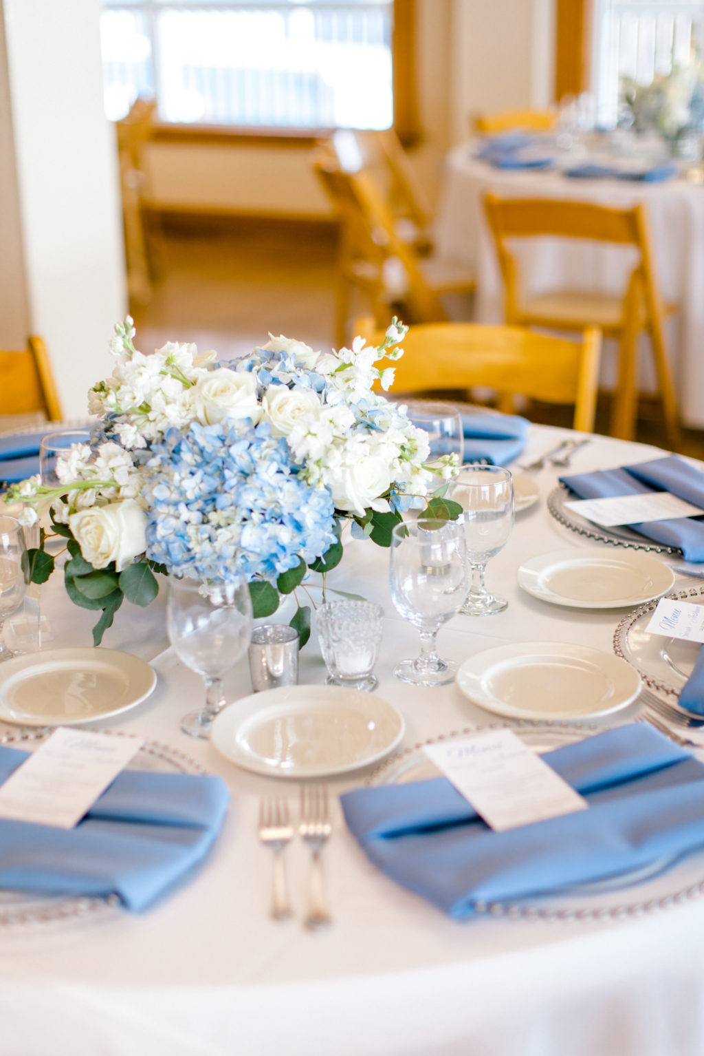 Blue and White Hydrangea Floral Centerpiece with Greenery and Acrylic Table Number | Dusty Blue Napkins | Wedding Reception Decor Ideas