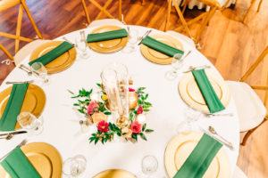 Green and Gold Wedding Place Settings with Vibrant Bright Pink Flowers and Greenery Candle Centerpiece | Wooden Chairs and White Linens | Rustic Garden Reception Decor Inspiration