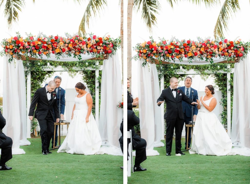Elegant Waterfront Outdoor Garden Jewish Wedding Ceremony Decor, Bride and Groom Exchanging Wedding Vows, White Folding Chairs, Tall Wooden Aisle Pedestals with Jewel Tone Floral Arrangements, Arch with White Linens and Flowers | Tampa Bay Wedding Venue The Resort at Longboat Key Club