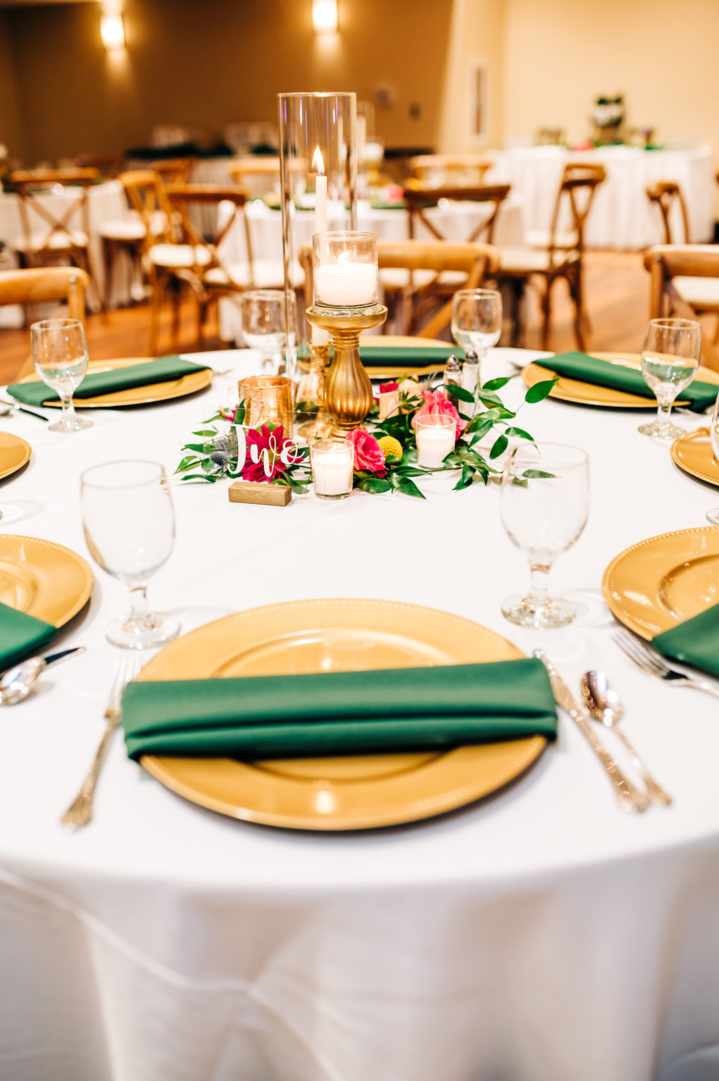 Green and Gold Wedding Place Settings with Vibrant Bright Pink Flowers and Greenery Candle Centerpiece | Wooden Chairs and White Linens | Rustic Garden Reception Decor Inspiration