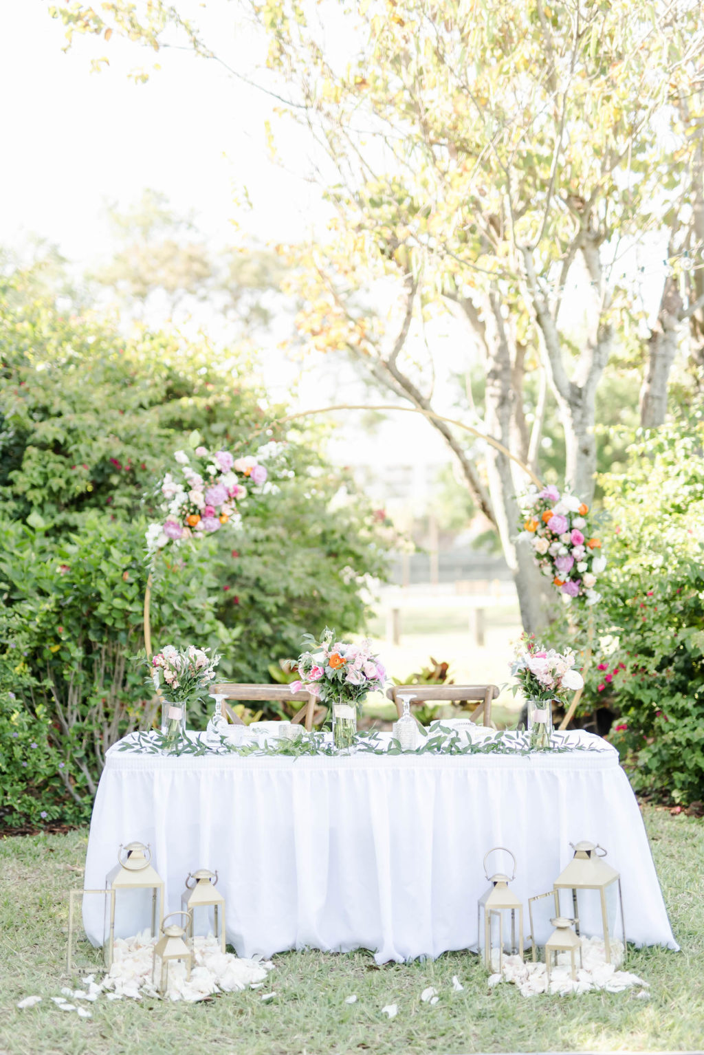 Wedding Sweetheart Table with White Linen | Gold Arch with Pink and White Florals and Laterns | Romantic Garden Wedding Reception Ideas | Tampa Bay Rental Company Outside the Box Event Rentals | Planner Special Moments Event Planning