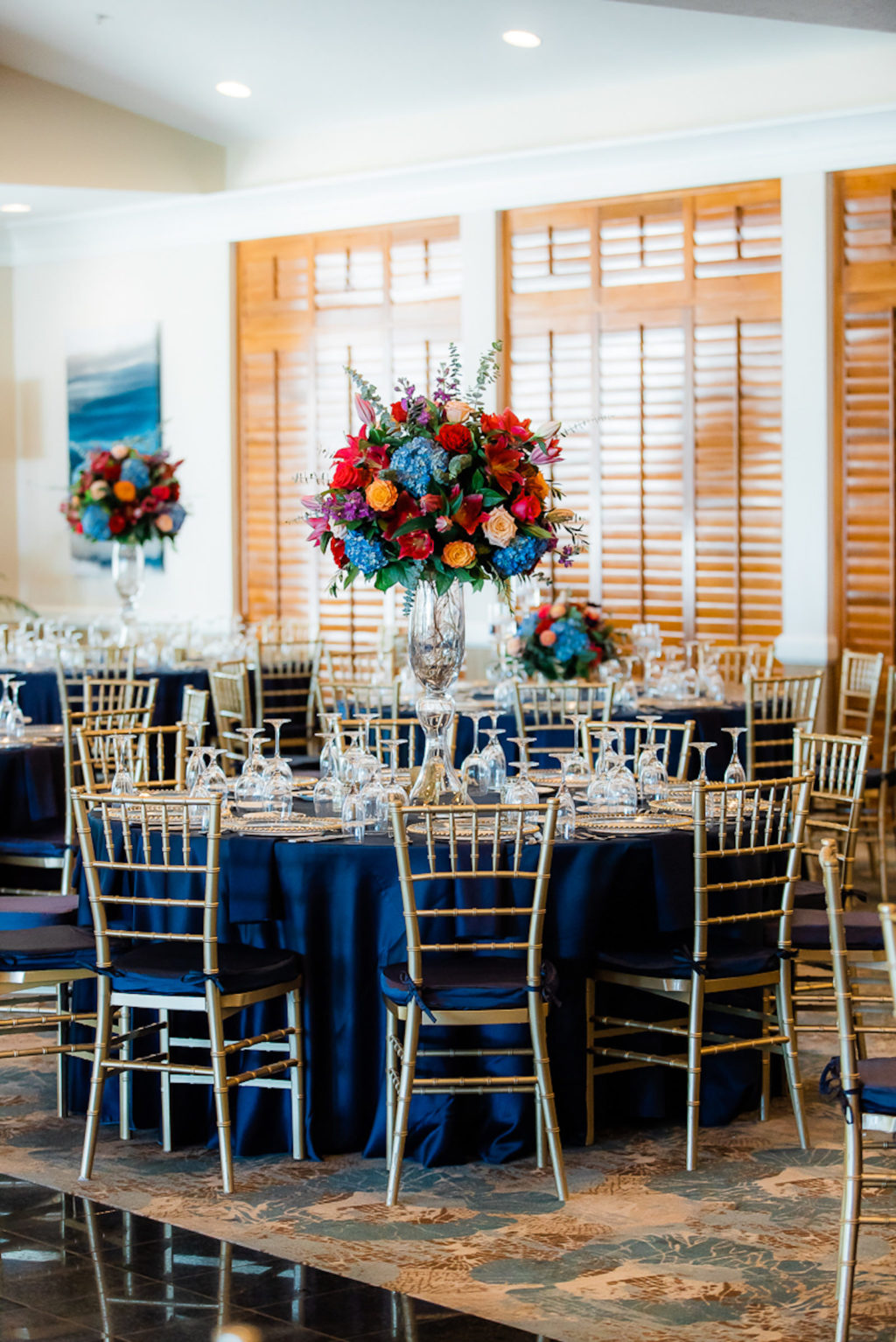 Elegant Ballroom Wedding Reception Decor, Gold Chiavari Chairs, Round Tables with Navy Blue Table Linens, Jewel Tone Tall Floral Centerpieces, Blue, Pink, Red, Orange Flowers | Tampa Wedding Venue The Resort at Longboat Key Club