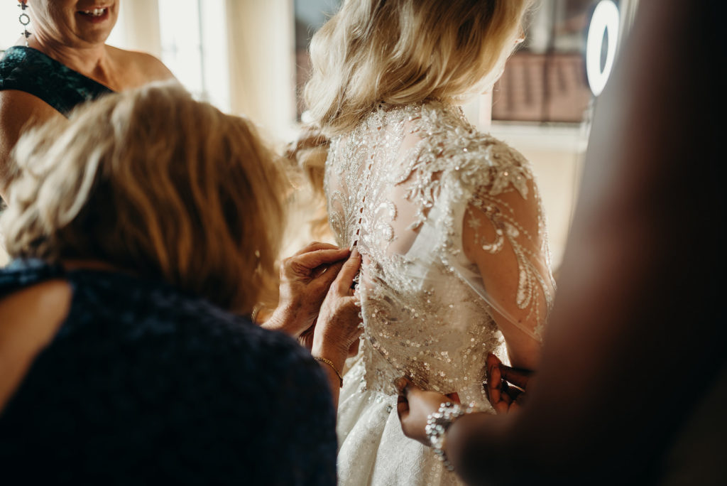 Florida Bride with Bridesmaids Helping Button Up Rhinestone Embellished Illusion Long Sleeve Wedding Dress