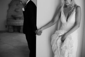 Unique Bride and Groom Holding Hands Behind Wall Secret First Look Wedding Photo