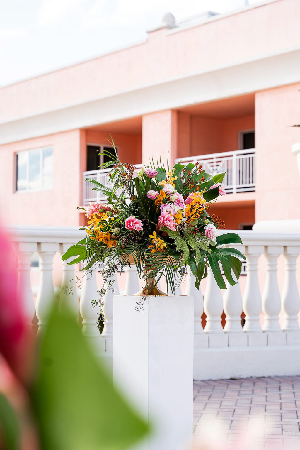 Tropical Rooftop Wedding Ceremony Decor, White Pedestal with Floral Arrangement, Monstera Palm Leaves, Pink Ginger, Yellow Flowers | Tampa Bay Wedding Photographer Limelight Photography | Clearwater Beach Wedding Venue Hyatt Regency Clearwater Beach