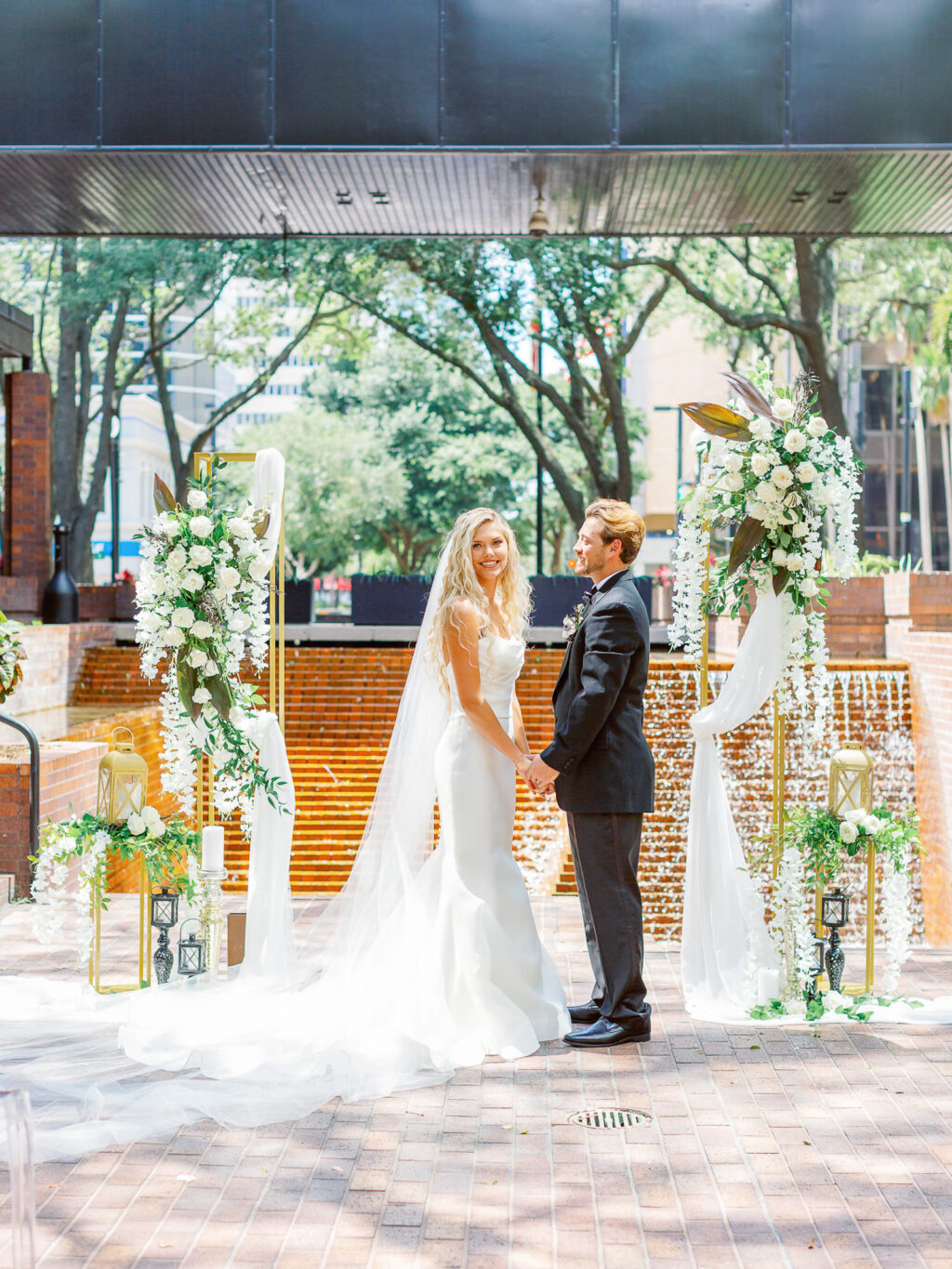 Bride in Tampa Wedding Ceremony in Fit and Flare Wedding Dress with Long Train Veil | Truly Forever Bridal