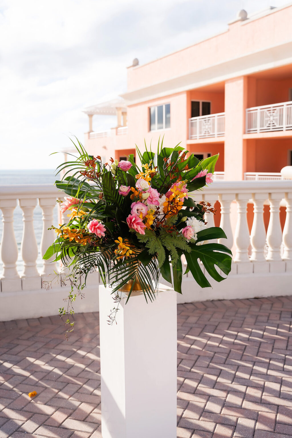 Tropical Rooftop Wedding Ceremony Decor, White Pedestal with Floral Arrangement, Monstera Palm Leaves, Pink Ginger, Yellow Flowers | Tampa Bay Wedding Photographer Limelight Photography | Clearwater Beach Wedding Venue Hyatt Regency Clearwater Beach