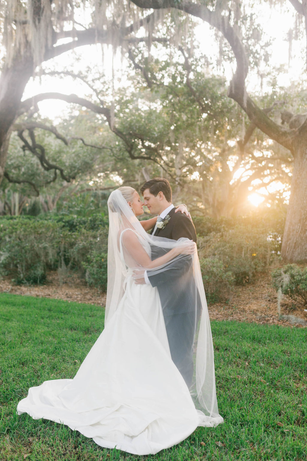 Bride and Groom Veil Shot Wedding Portrait | Bride in BHLDN Illusion Back Ballgown with Classic Updo and Natural Makeup | Tampa Bay Hair and Makeup Artist Femme Akoi Beauty Studio