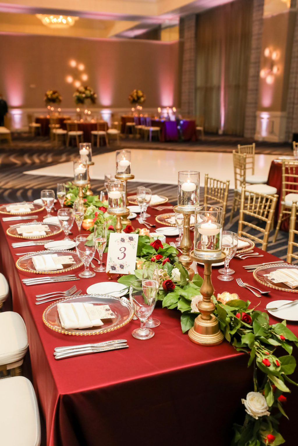 Indian Hindu Wedding Ballroom Reception Decor, Long Table with Burgundy Red Table Linen, Clear and Gold Beaded Charger, Greenery Garland Table Runner, Floating Candlesticks, Gold Chiavari Chairs | Tampa Bay Wedding Photographer Lifelong Photography Studios | Wedding Venue Grand Hyatt Tampa Bay