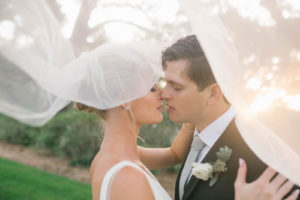 Bride and Groom Veil Shot Wedding Portrait | Bride in BHLDN Illusion Back Ballgown with Classic Updo and Natural Makeup | Tampa Bay Hair and Makeup Artist Femme Akoi Beauty Studio