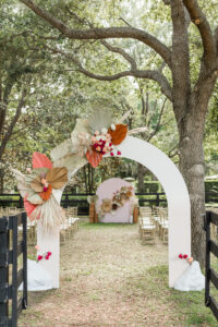 Boho Mid-Century Modern Outdoor Wedding Ceremony Decor, White Arch with Sage Green, Burnt Orange and Coral Pink Dried Leaves, Pampas Grass | Arch West & Rock Designs | Tampa Bay Wedding Ceremony Backdrop Designer Taylored Affairs | Florida Wedding Venue Mision Lago Estates | Big Fake Wedding