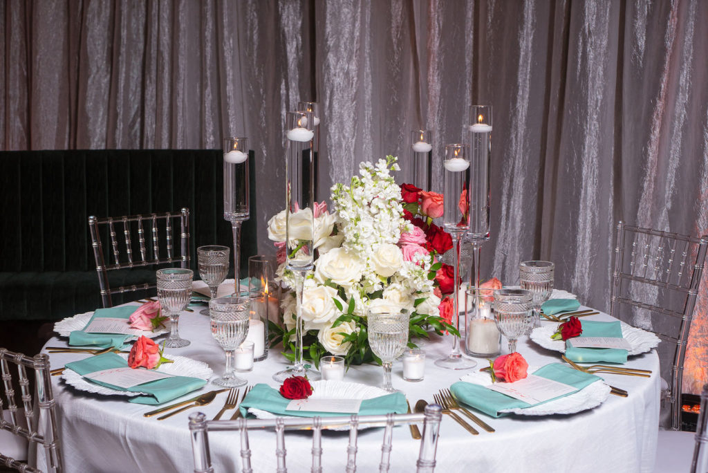 Modern Florida Wedding Reception Decor, Romantic Tall Floating Candles with Low Floral Centerpiece, Pink, White and Red Roses, Teal Linens, Ghost Chiavari Chairs | 7th and Grove