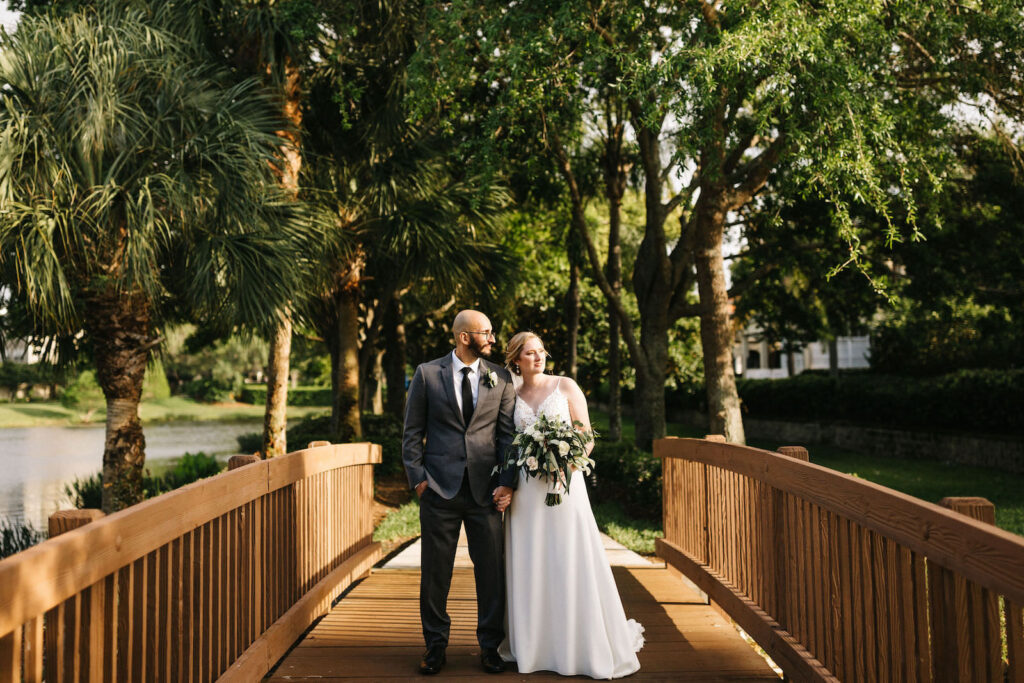 Bride and Groom Outdoor Wedding Portrait in Harbour Island Downtown Tampa | Sheath Satin Charmeuse V Neck Lace Bodice Spaghetti Strap Bridal Gown | Groom Wearing Classic Charcoal Grey Suit