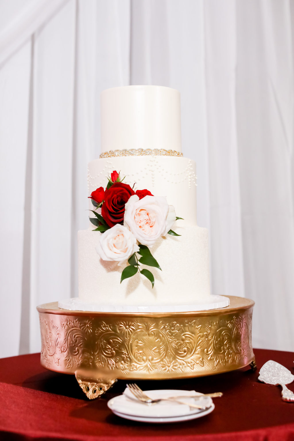 White Three Tier Wedding Cake on Gold Cake Stand, Blush Pink and Red Roses Arrangement | Tampa Bay Wedding Photographer Lifelong Photography Studios | Wedding Baker The Artistic Whisk