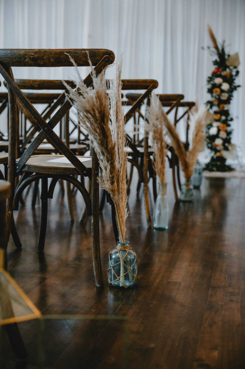 Wooden Wedding Ceremony Chairs and Pampas Leaves in Clear Vases | Wedding Ceremony Bohemian Aisle Décor | South Tampa Decor Kate Ryan Event Rentals